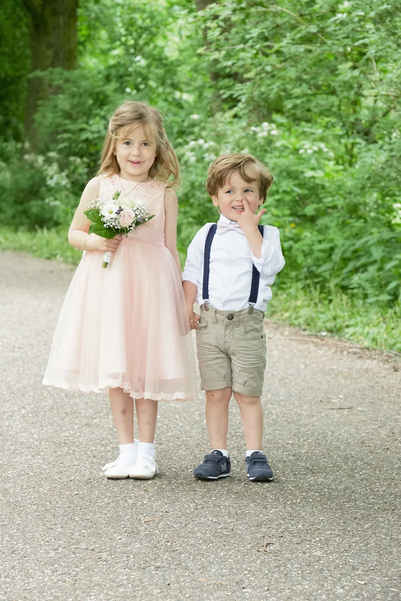 De kinderen lopen samen over het pad, met bloemetjes in de hand