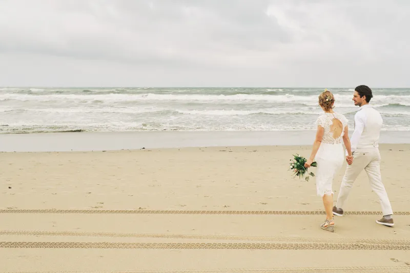Annemieke en Jaap lopen samen over het lege strand