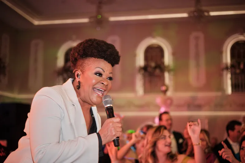 Een zangeres in een wit jasje zingt voor de zaal