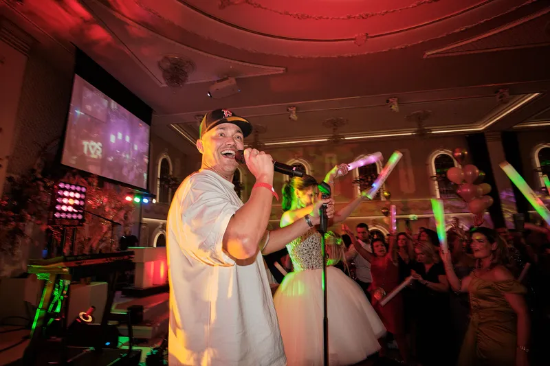 Een rapper met pet zingt met Sascha