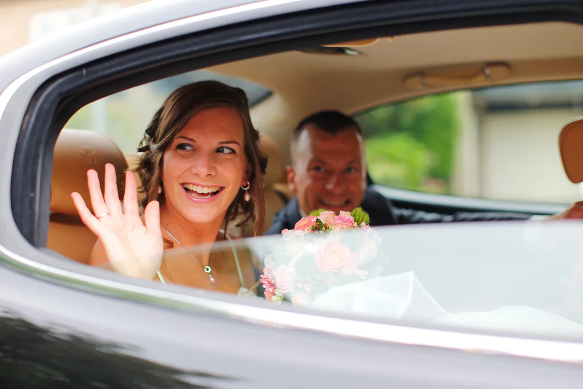 Aniek zwaait vanuit de zwarte Maserati