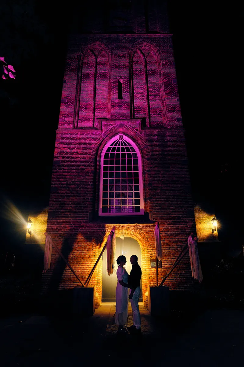 Elles en Bram als silhouet in de verlichte deur van de toren