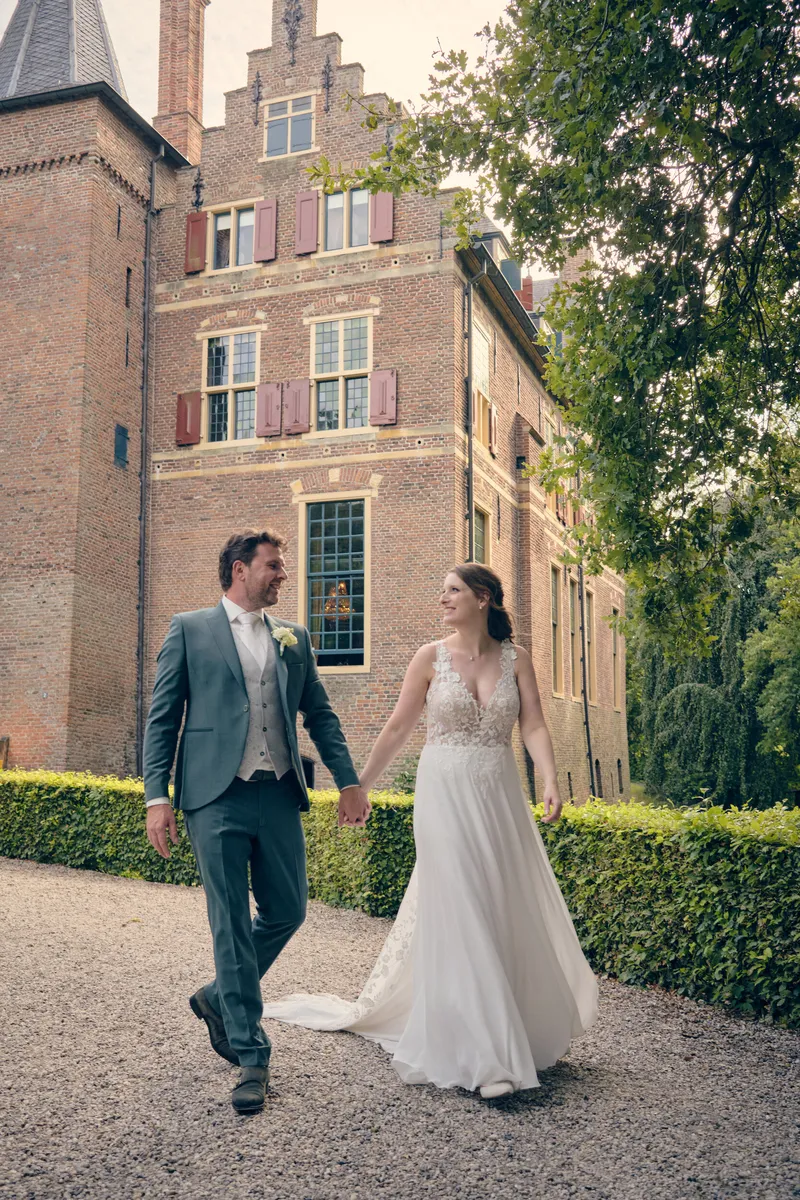Fabian en Renée lopen hand in hand over het grind voor het kasteel