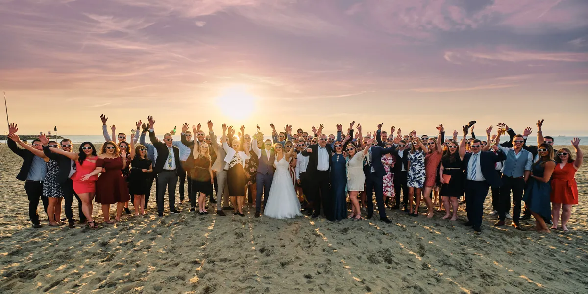 De gasten juichen op het strand bij zonsondergang