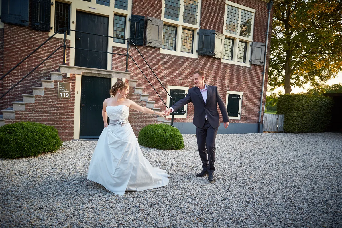Linsey en Tim dansen hand in hand over het grind voor de Hofstede