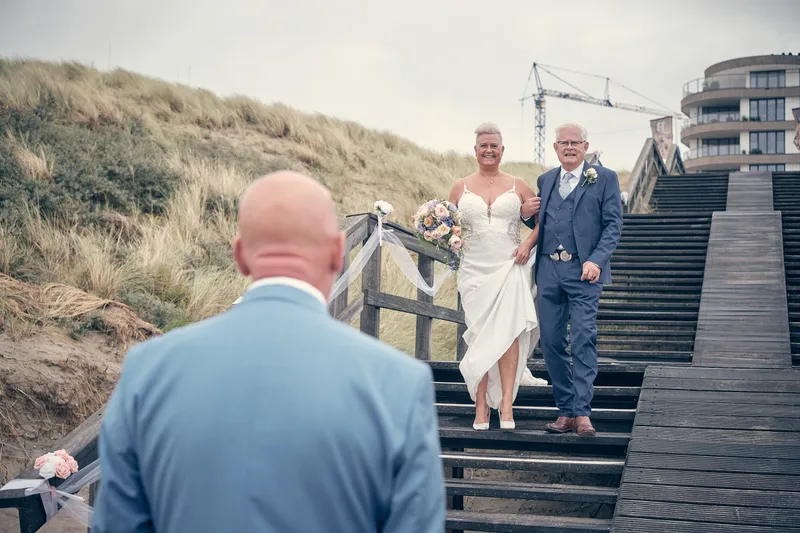 Silvia komt met haar vader de trap af door de duinen