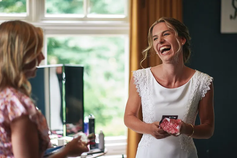 Karien lacht uitbundig met een vriendin in de slaapkamer