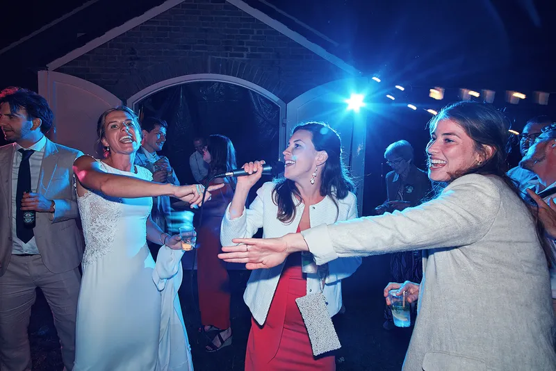 Karien lacht op de dansvloer terwijl een gast zingt