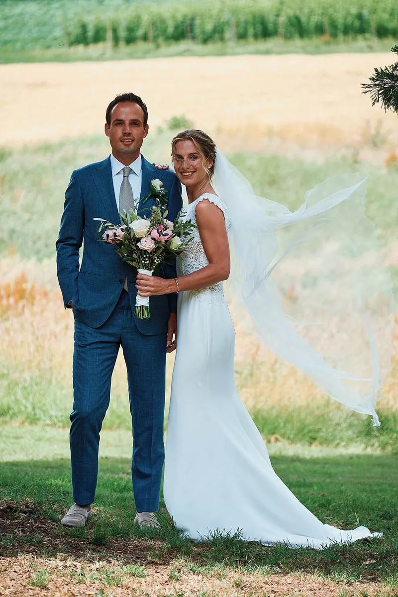 Karien en Niels in het veld, de sluier waait in de wind
