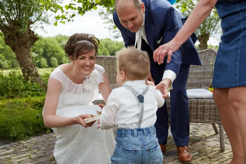 Marina geeft hun zoontje een stukje brood, Erik lacht