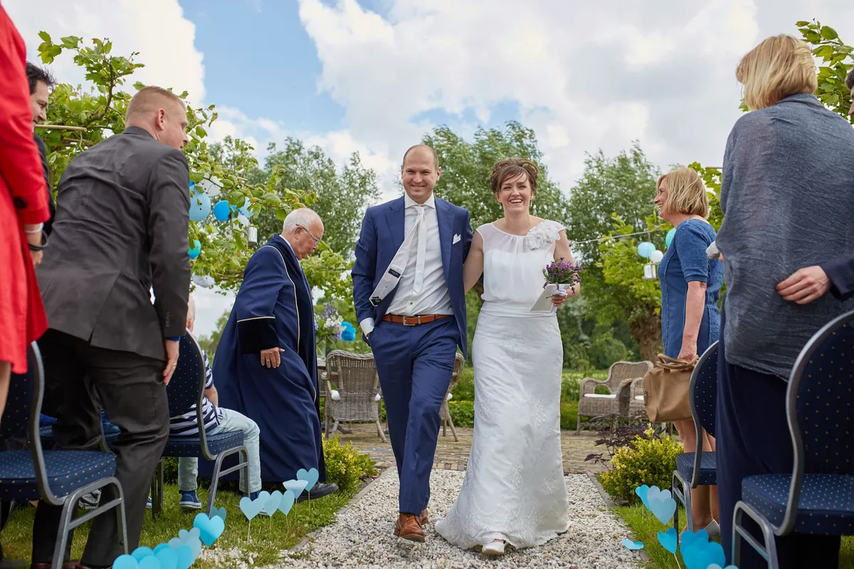 Marina en Erik lopen als getrouwd stel over het grindpad, langs de gasten