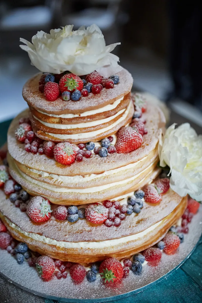 Naked cake met aardbeien, bosbessen en witte pioenrozen