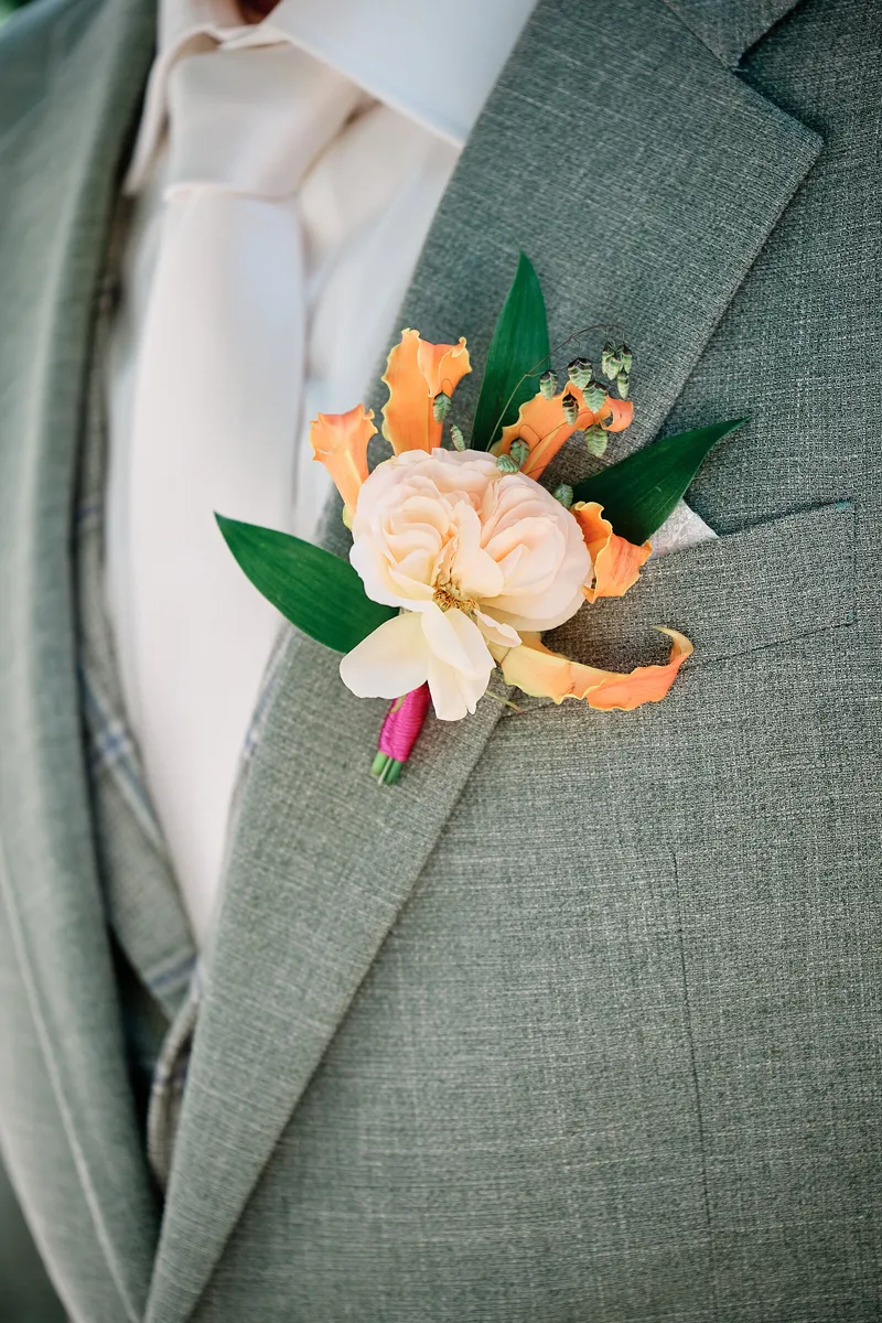 De oranje corsage op het grijze colbert van Michael