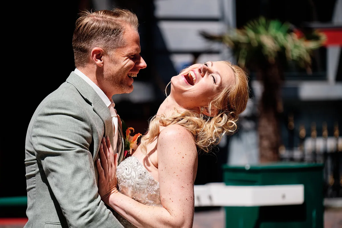 Neomi lacht met haar hoofd achterover in de armen van Michael
