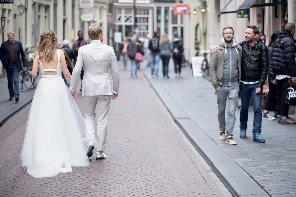 Mary en Jasper lopen over de Zeedijk tussen het publiek