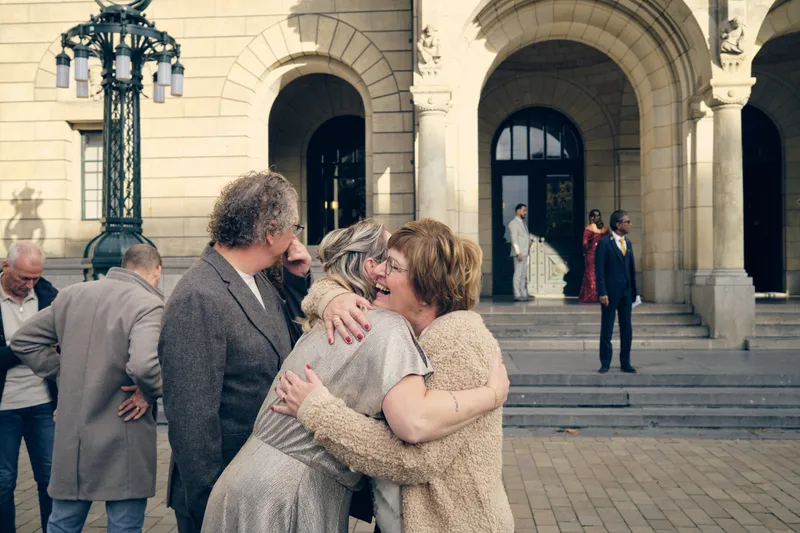 Jiska wordt omhelsd door een gast op de trappen van het stadhuis
