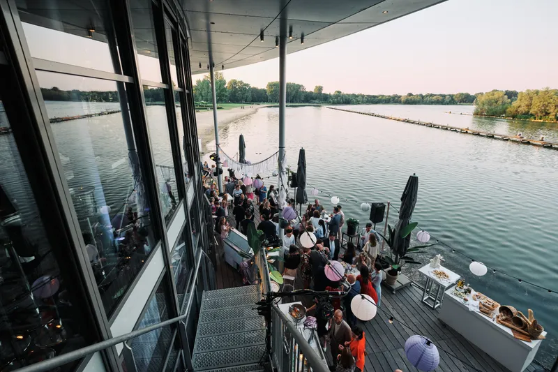 Het terras van The Boathouse vol gasten, met uitzicht over de Kralingse Plas