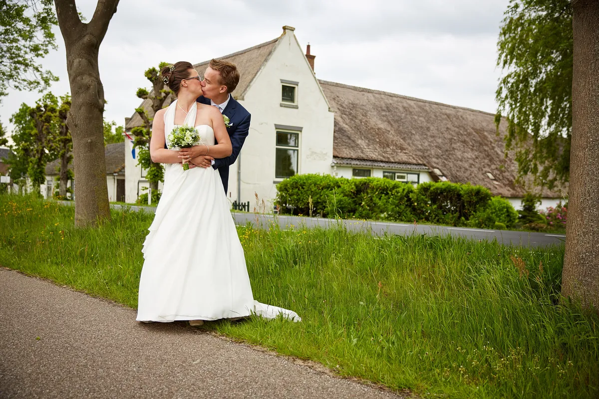 Marjolein en Coen kussen elkaar op het weggetje bij de boerderij