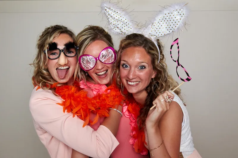Drie vriendinnen met brillen en een boa in de fotobooth