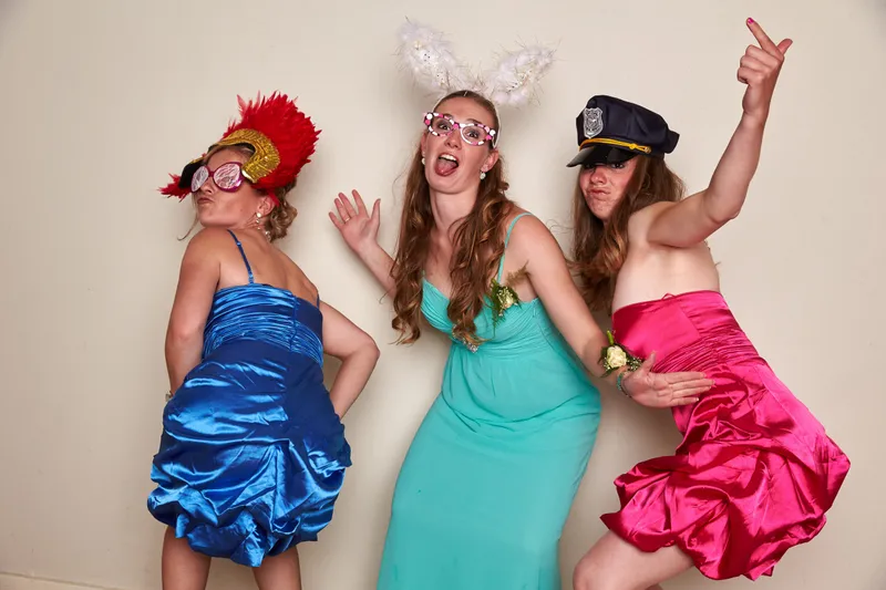 Drie gasten in glimmende jurken in de fotobooth
