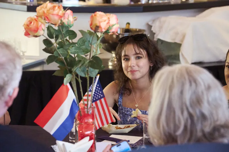 Een Nederlandse en een Amerikaanse vlag tussen de rozen op tafel