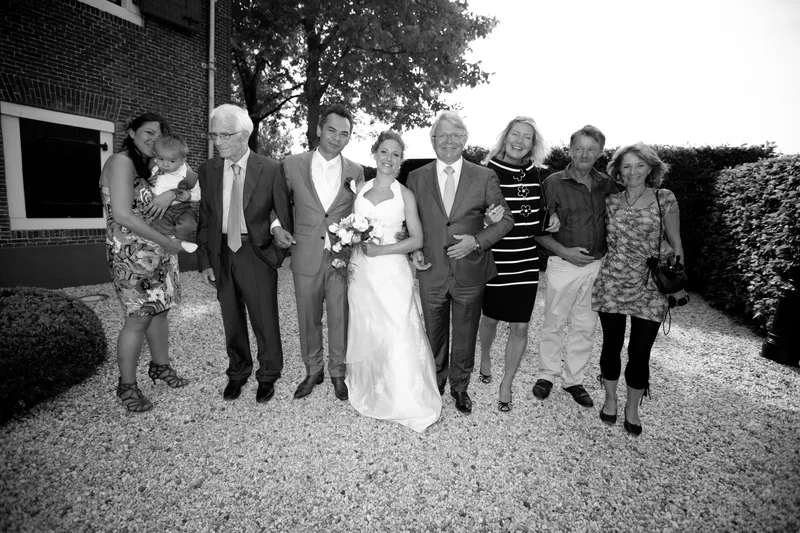 Een groepsfoto met familie in de tuin, in zwart-wit