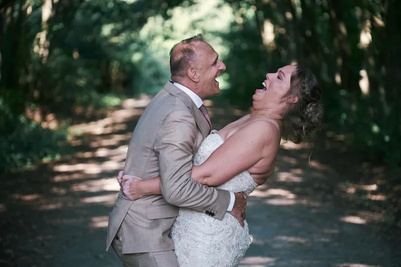 Mirjam lacht met haar hoofd achterover in de armen van Jorg