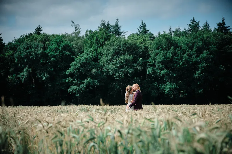 Simon en Mariëth in een korenveld voor de bomenrij