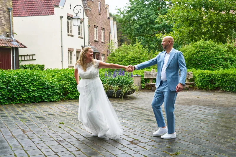 Annemarie trekt Jan aan zijn hand over het pleintje