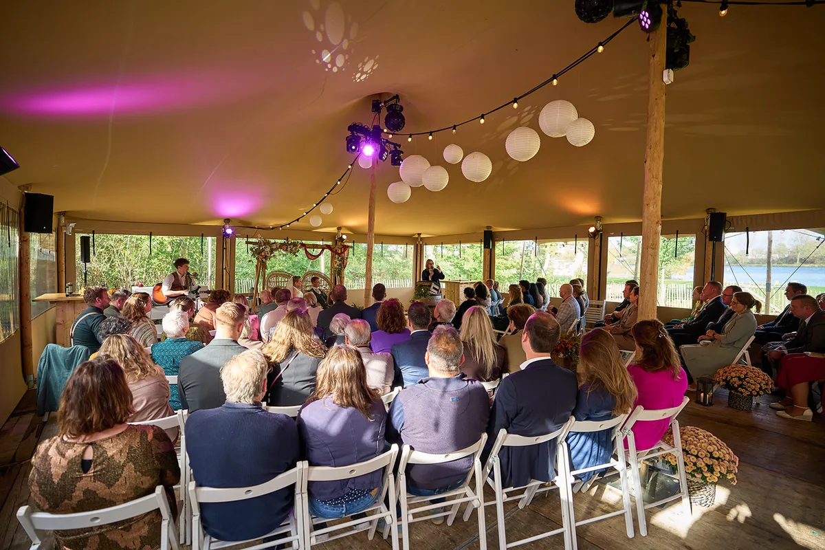 De tent bij Breezze tijdens de ceremonie, met roze licht en lampionnen