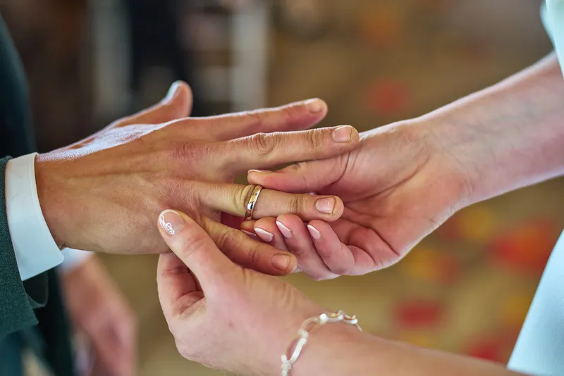 Handen met trouwring en bedelarmband