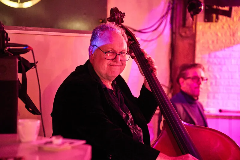 Contrabassist in roze licht
