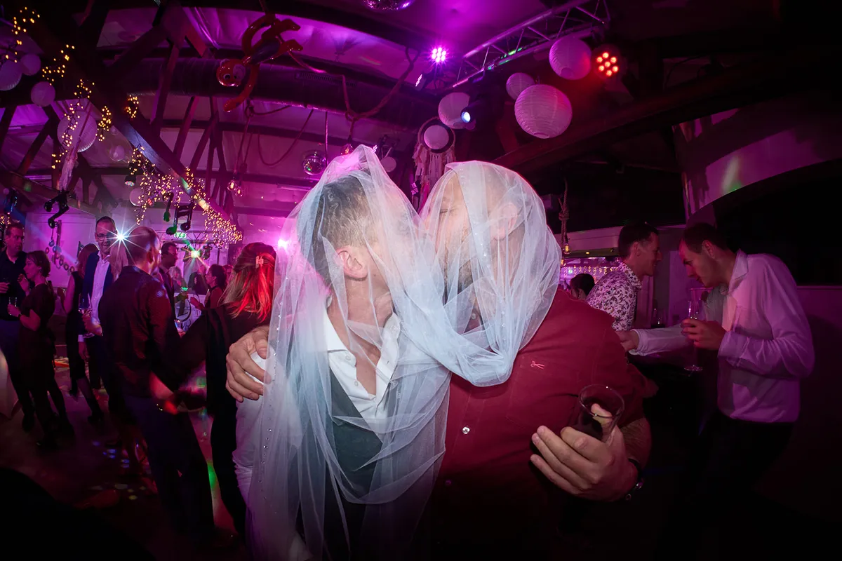 Karlijn en Glenn kussen onder de sluier op de dansvloer