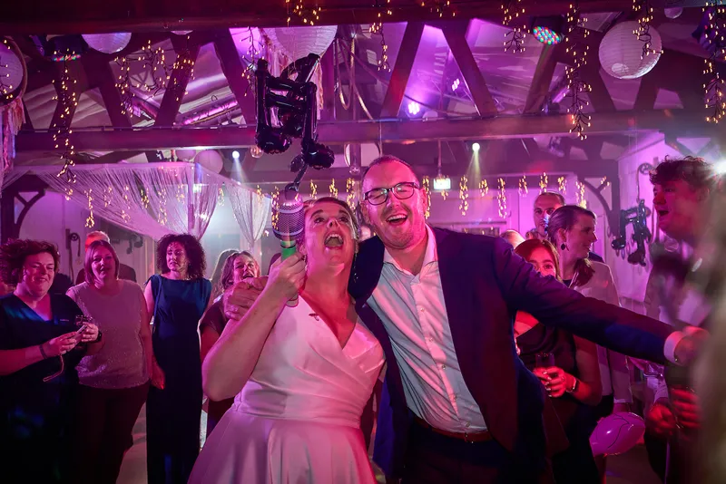 Karlijn en Glenn lachen met champagne op het feest