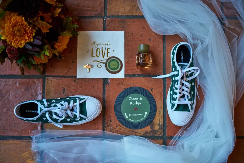 Groene sneakers, bloemen, de sluier en een onderzetter met de namen en de trouwdatum