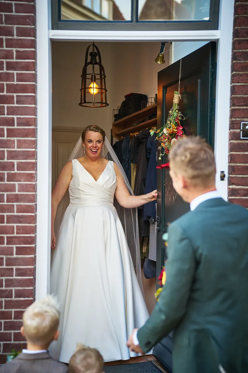 Karlijn staat lachend in de deuropening van het oude huis