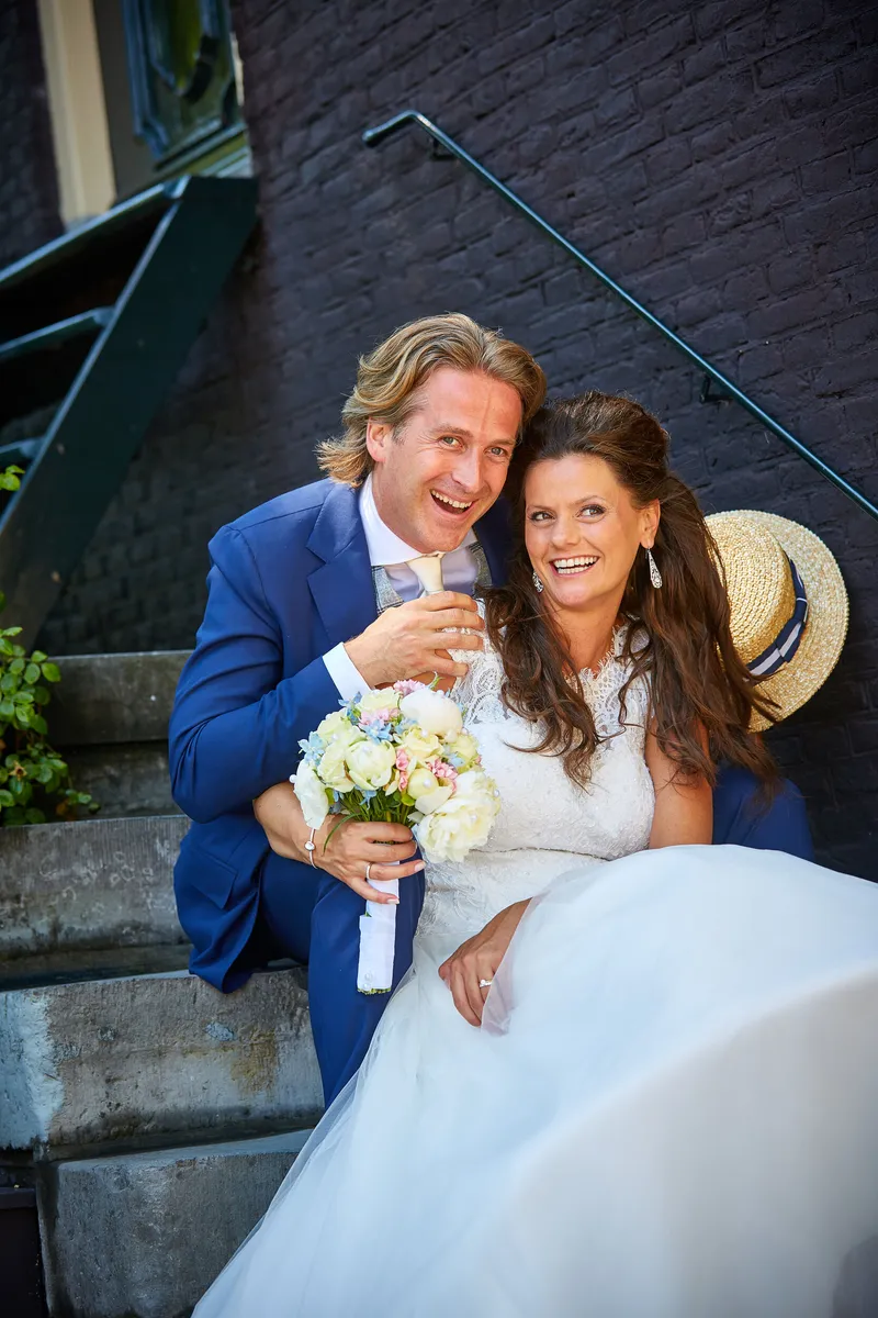 Rinkje en Wouter lachen op een stoep in de stad