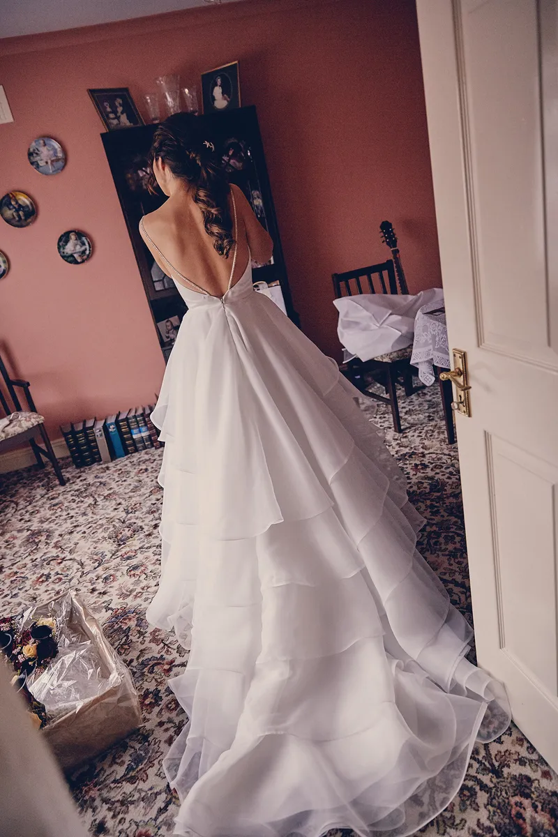 Caitriona in haar jurk met de lange sleep, in de slaapkamer