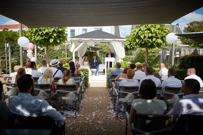De tuin met de gasten onder de witte paviljoens