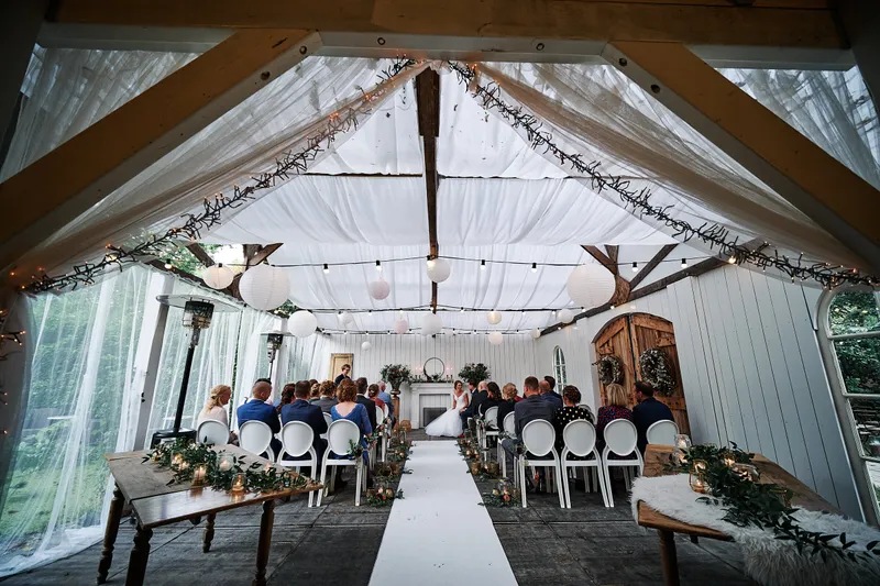 De witte tent met het gangpad en de stoelen, klaar voor de ceremonie