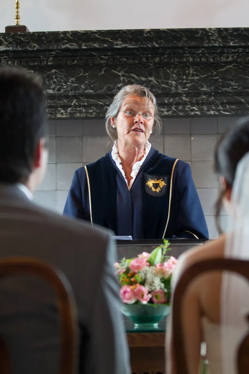 De trouwambtenaar achter de tafel met bloemen