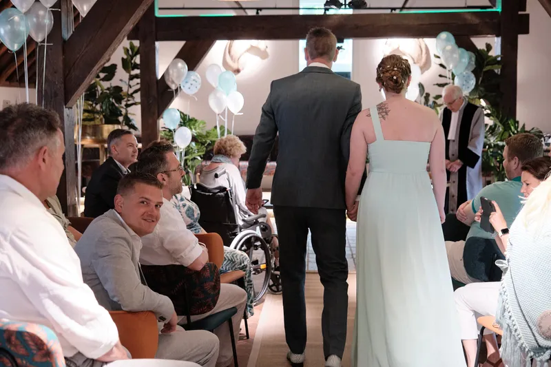 Marleen en Eric lopen de zaal in tussen de gasten