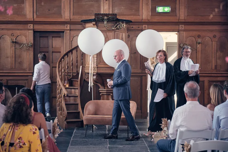 Bram loopt tussen de witte ballonnen naar voren