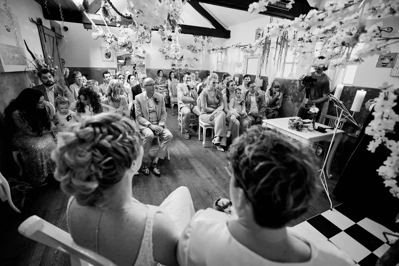 De zaal vol gasten onder de bloemen aan het plafond