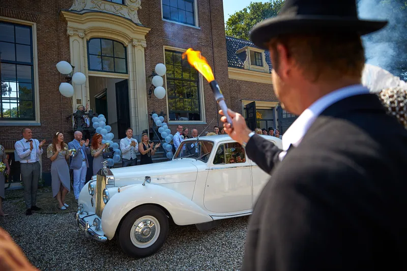 Een gast met een rokende fakkel bij de Rolls-Royce