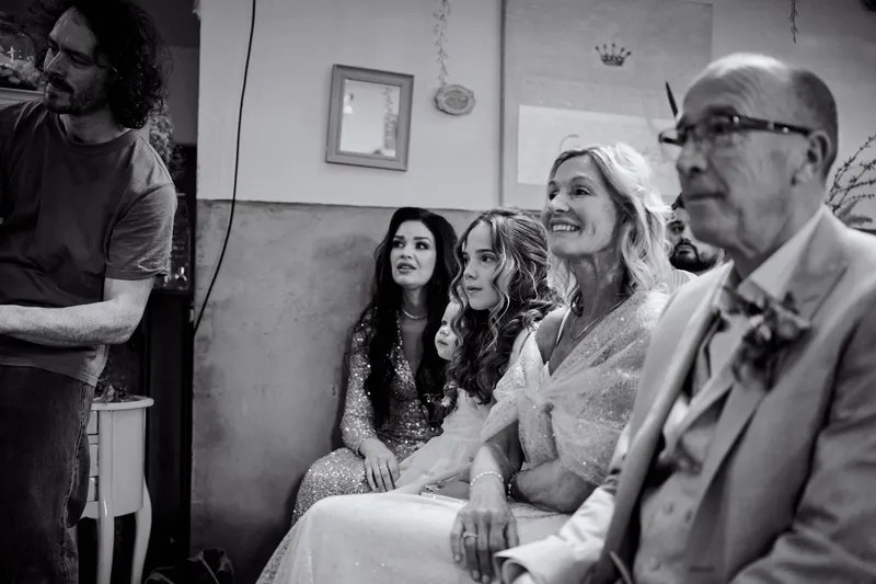 Familie op de eerste rij luistert naar de ceremonie, in zwart-wit