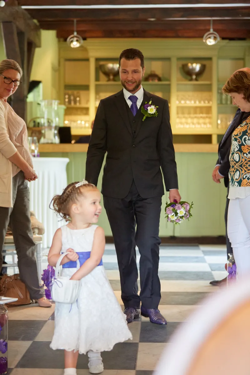 Nadine komt binnen, met een bloemenmeisje voor haar uit