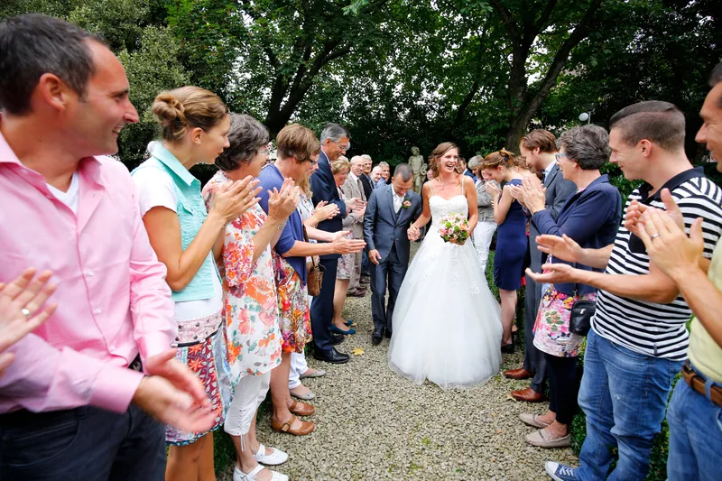 De gasten klappen terwijl het paar voorbij loopt