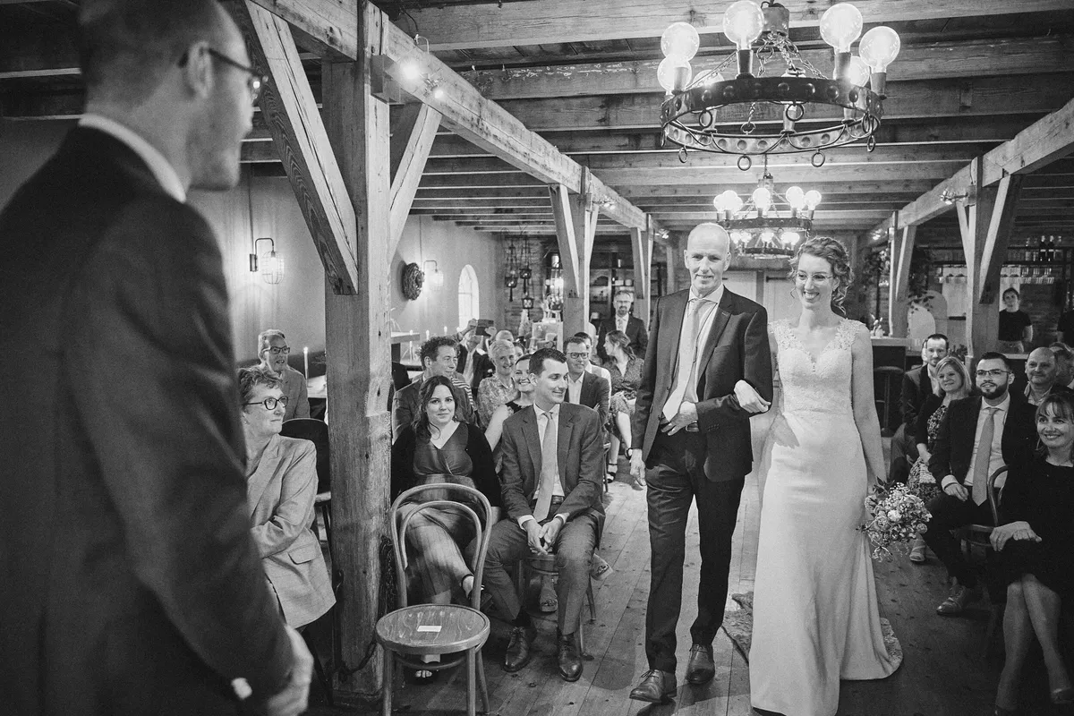 Ilse komt met haar vader de schuur van Burgersdijk binnen, onder de houten balken