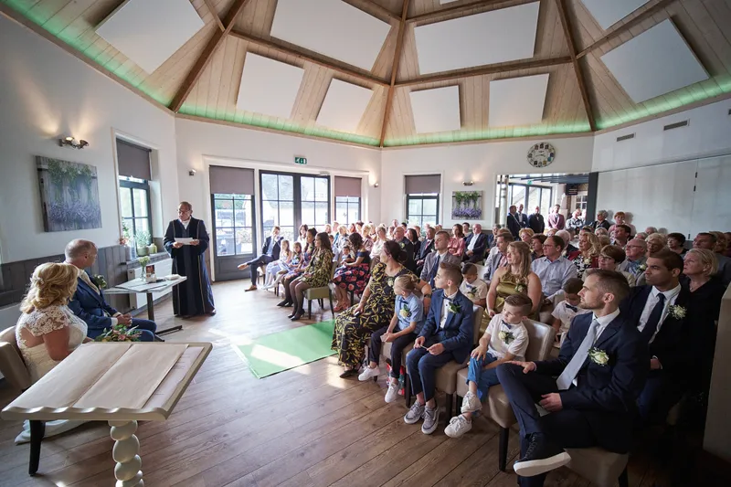De ronde trouwzaal met het houten plafond, vol gasten
